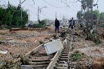 TOPSHOT - Residents walk among debris on a rail track following flood in Picanya, near Valencia, eastern Spain, on October 30, 2024. Floods triggered by torrential rains in Spain's eastern Valencia region has left 51 people dead, rescue services said on October 30. (Photo by Jose Jordan / AFP) (Photo by JOSE JORDAN/AFP via Getty Images)